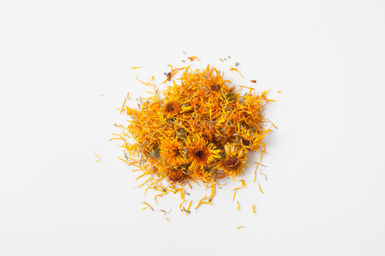Dry calendula flowers pour a handful on white