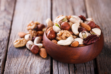 Nuts Mixed in a wooden plate.Assortment, Walnuts,Pecan,Almonds,Hazelnuts,Cashews,Pistachios.Concept of Healthy Eating.Vegetarian.selective focus.
