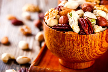 Nuts Mixed in a wooden plate.Assortment, Walnuts,Pecan,Almonds,Hazelnuts,Cashews,Pistachios.Concept...