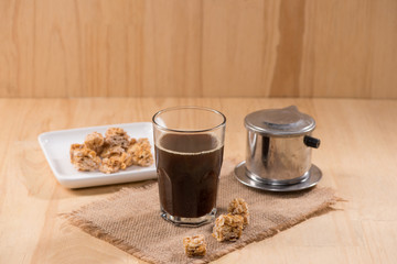 Obraz na płótnie Canvas Coffee serve with almond candies on a wooden table.