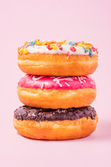 Delicious donuts for birthday on pastel pink background.