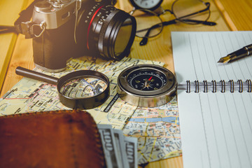 The compass is placed on a city map with objects nearby. Tone of photo is vintage style.