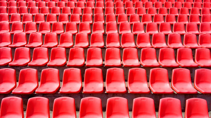 Rows of red plastic seats grandstand stadium