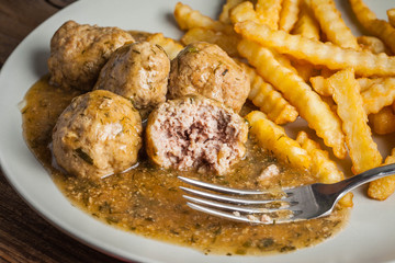 Meatballs with french fries in dill sauce.