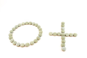 Circle, plus sign and spirulina pills.