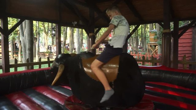 young guy riding a mechanical bull