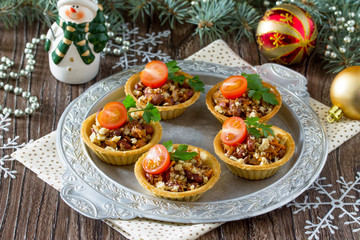 Tartlets with beans, meat and walnuts. Beautiful Christmas and New Year's food background. Selective focus.
