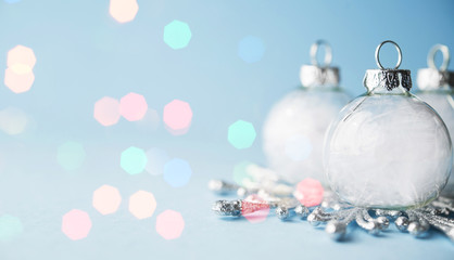 Christmas background with white ornaments on light blue background with colorful bokeh lights....