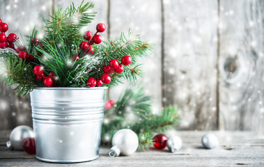 Christmas composition with spruce, red berries and white, silver, red xmas ornaments on rustic wood...