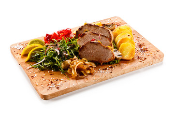 Roast steak with potatoes on cutting board