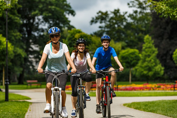 Naklejka premium Healthy lifestyle - people riding bicycles in city park 