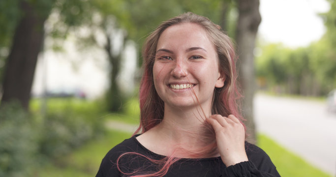 Happy Smiling Teen Girl With Purple Hair Standing In Town