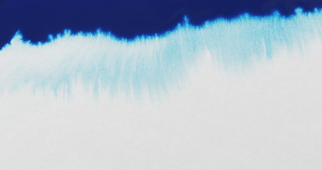 closeup blue ink border spreading on wet paper top view