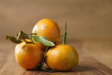 organic tangerines with leaves on wood table