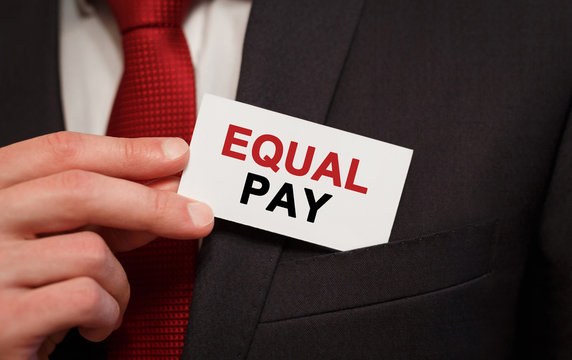 Businessman putting a card with text Equal Pay in the pocket