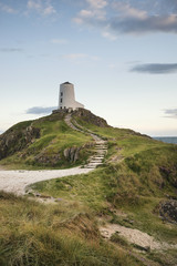 Stunning Summer landscape image of lighthouse on end of headland with beautiful sky