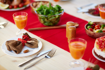 Glasses with juice, salad and vegs on served festive table