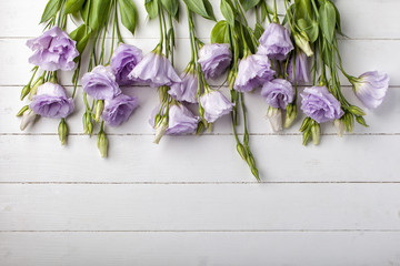 Flowers border on white wooden background. Top view with copy space