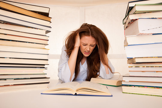 attractive young woman student undre stress while studiing for exames