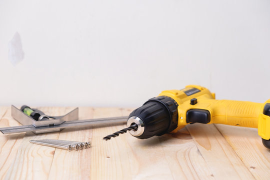 Close up yellow power drill on wooden. Do it your self concept.