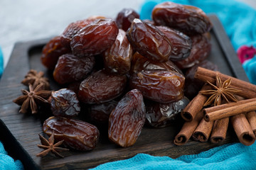 Close-up of date fruits with star anise and cinnamon sticks, selective focus
