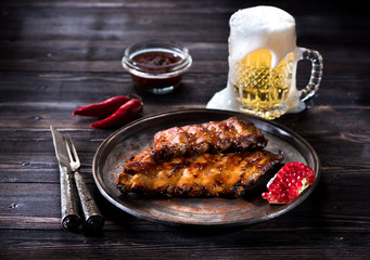 Grilled pork baby ribs with barbecue sauce  and a mug beer