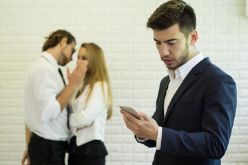 Businesswoman using smartphone while coworker interacting in the background in the office