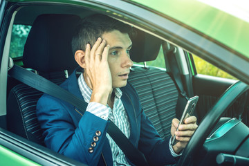 Driver man with a phone in hands makes an accident. Fright, inconsiderate and dangerous driving. The traffic violation.