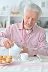 man pouring milk in cup