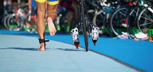 Crédence de cuisine en verre imprimé Vélo Vélo de triathlon la zone de transition, le triathlonien court sur un vélo