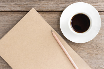 Obraz na płótnie Canvas brown notebook with coffee cup on wooden background.