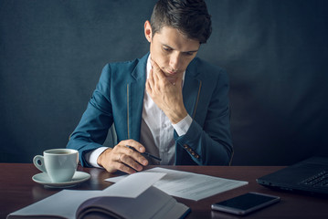 Businessman signs important legal documents on the desktop with Cup of coffee