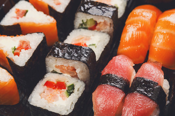 Set of sushi maki and rolls closeup in delivery box