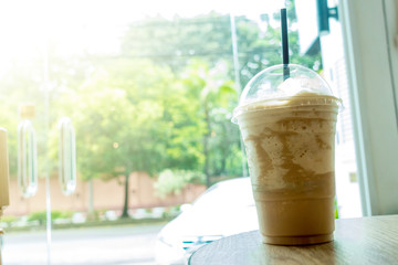 Frappe coffee on wood table with roadside view