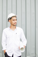 Portrait of professional engineer holding a blueprint in hand.