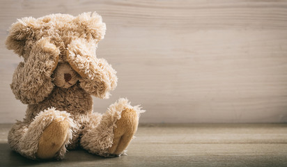 Child abuse concept. Teddy bear covering eyes - obrazy, fototapety, plakaty