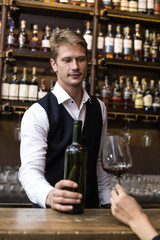 Bartender serving Wine to Customer at counter, Bartender enjoy to serving Wine for Customer, People Lifestyle Concept.