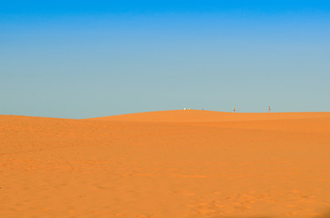 Beautiful white sand dunes ripples in sunrise morningat at Red sand dunes in Muine, Vietnam. Vacation concept background.