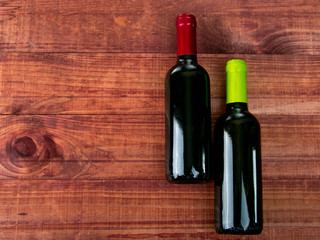 Two bottles of wine. versions of beverage on a wooden table. Cropped still life with copy space for...