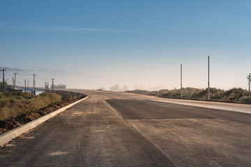 asphalt road with in foggy summer morning.