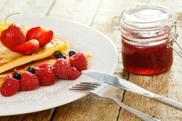 Pancakes with berries and sugar powder