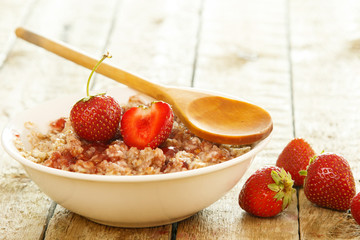 Cooked oatmeal, berries and strawberry jam