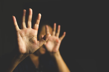Woman with her hand extended signaling to stop (only her hand is in focus)