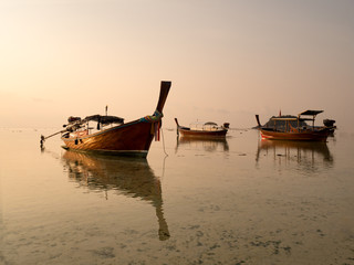 Local long tail boat in sea at sunrise when tide is falling or going out. Peaceful feeling at Lipe Island, Satun, Thailand.