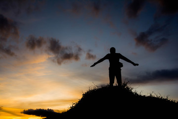 man  in silhouette  jumping on hill with sky for background