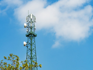 Green tower with microwave link and TV transmitter antennas, telecommunication mast antennas...