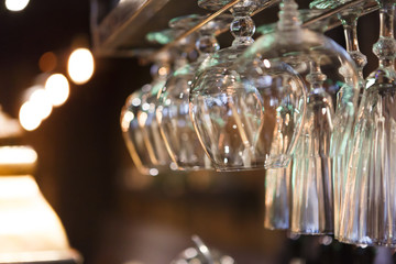Glasses hanging on bar rack close up
