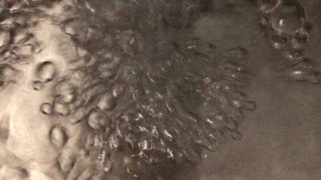 Water flowing to zinc bucket and making plenty of bubbles