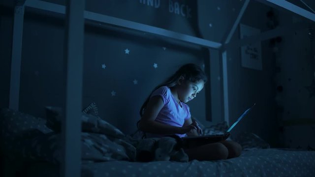 Little girl using laptop at night