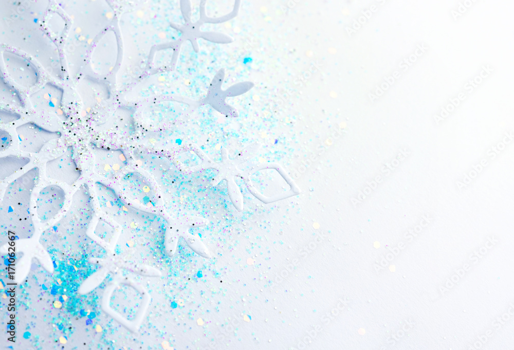 Poster Light blue white Christmas and New Year background. Snowflake in sequins close-up macro with a soft focus. Delicate elegant artistic template for greeting text for the Christmas holidays.